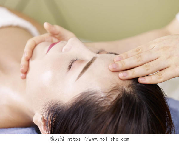 年轻亚洲女性接受面部按摩面部清洁脸部面部按摩补水